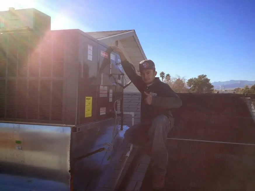 HVAC technician performing HVAC Inspection on a rooftop unit in Charleston